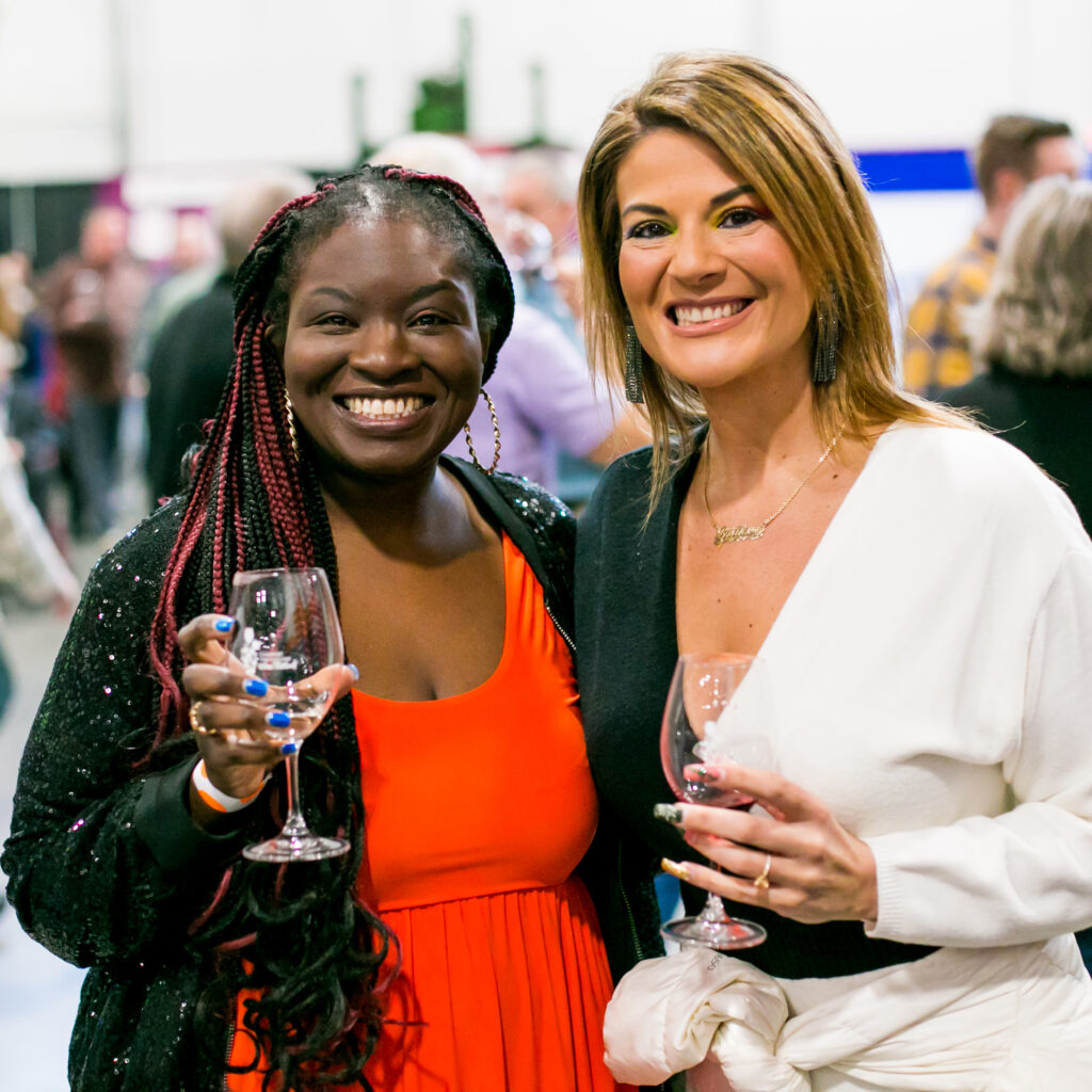 two women holding wine glasses smiling