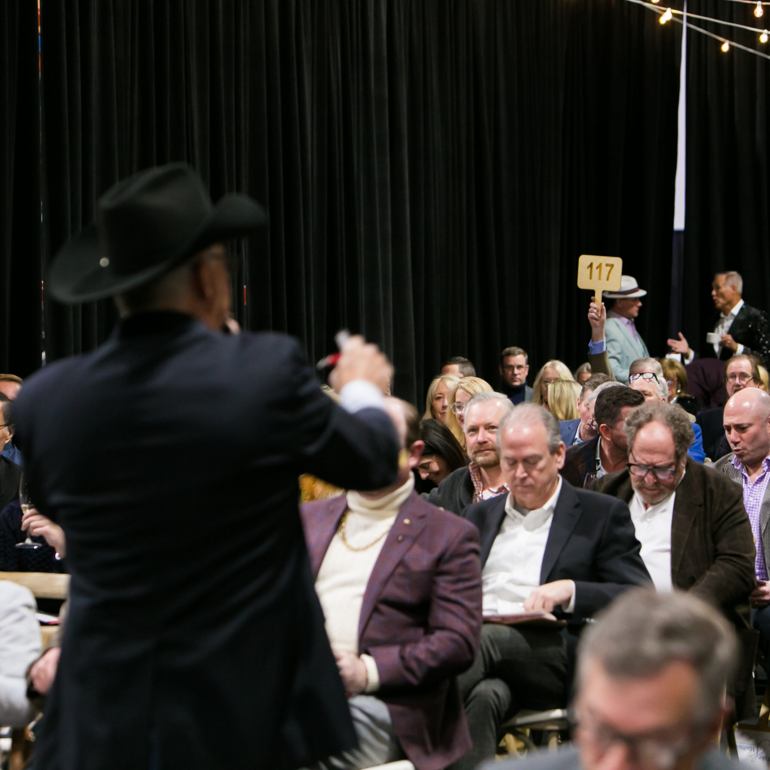auctioneer with paddle raised in the background